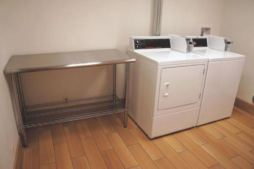 a small white refrigerator and a counter in a room at La Quinta Inn & Suites by Wyndham Detroit Metro Airport in Romulus