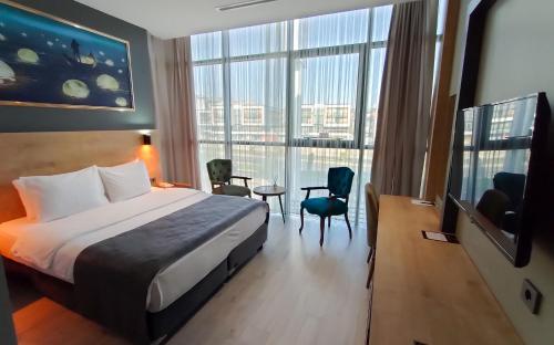 a hotel room with a bed and a large window at MİLLS HOTEL in Tekirdag
