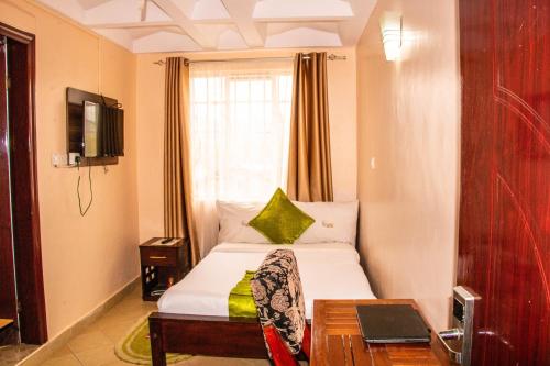 een hotelkamer met een bed en een raam bij Luna hotel in Nakuru