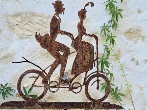 a metal statue of two women riding a bike at Chambre d'hôtes "Au bord de Loire" in La Marche