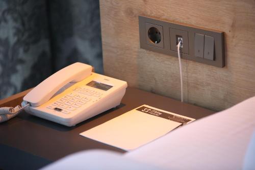 a phone is sitting on a desk next to a bed at MİLLS HOTEL in Tekirdag