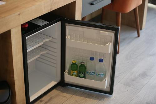 an open refrigerator with bottles of water in it at MİLLS HOTEL in Tekirdağ