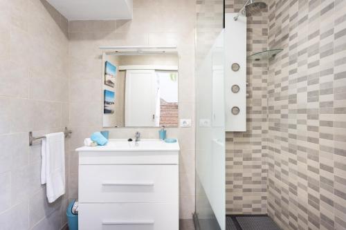 a white bathroom with a sink and a mirror at Home2Book Ocean Breeze Candelaria, Terrace & Pool in Candelaria