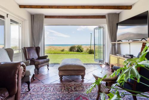 een woonkamer met uitzicht op de oceaan bij Strand Beach Lodge in Strand