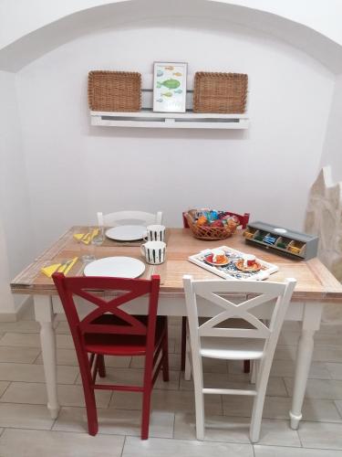 a dining room table with two red chairs and a white table at Albero di giada in Massafra
