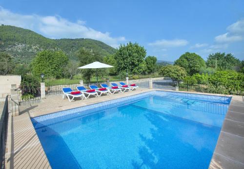 a swimming pool with lounge chairs and an umbrella at Owl Booking Villa Sedes - Dive Into Nature in Campanet
