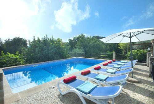 a pool with lounge chairs and an umbrella at Owl Booking Villa Sedes - Dive Into Nature in Campanet