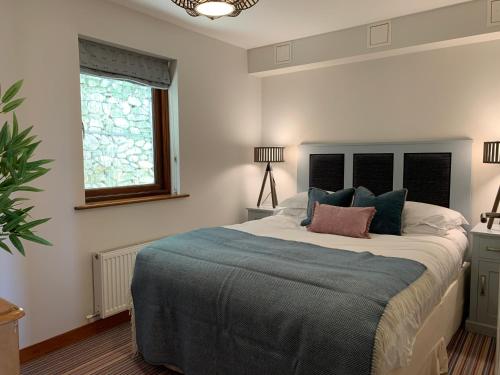 a bedroom with a large bed with a blue blanket at White Lodge - Coast Hideaways in Mawgan Porth