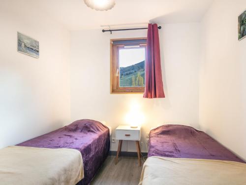 zwei Betten in einem Zimmer mit Fenster in der Unterkunft Les Huskies- 48- Refait a Neuf- 6 pers in Saint-Sorlin-dʼArves