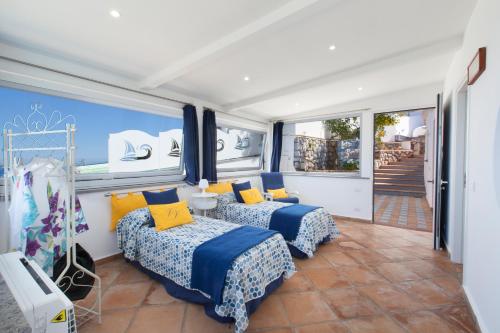 two beds in a room with two windows at Villa Venus in Penisola sorrentina in Massa Lubrense