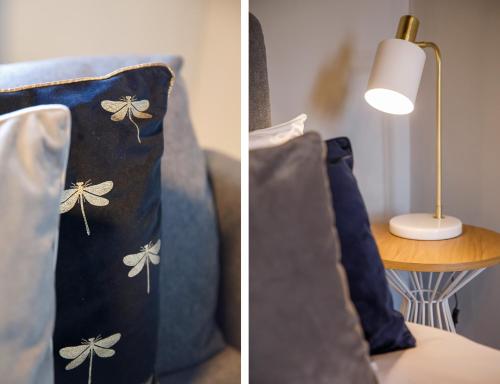 a blue couch with a pillow and a lamp on a table at Bateman, modern City centre apartment sleeps 6 in York