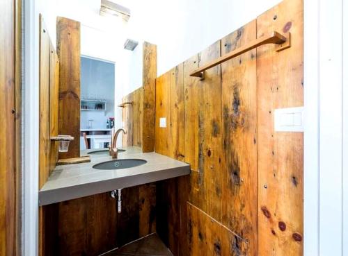 La salle de bains est pourvue d'un lavabo et d'un mur en bois. dans l'établissement Casa Mary, à Castellammare del Golfo