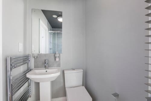 Baño blanco con aseo y lavamanos en Bateman, modern City centre apartment sleeps 6, en York
