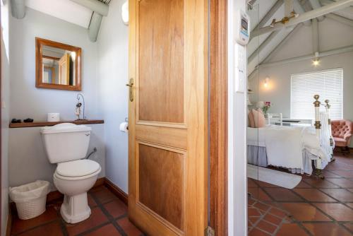 a bathroom with a toilet and a sink at Strand Beach Lodge in Strand