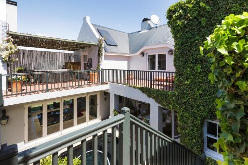 a white house with a green ivy at Strand Beach Lodge in Strand