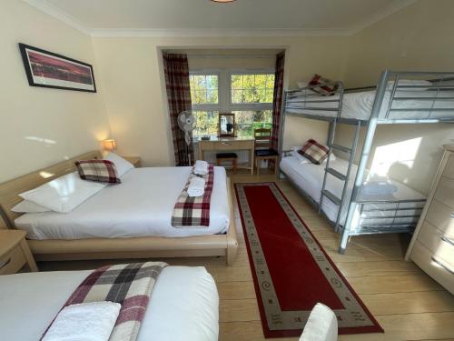 a bedroom with two bunk beds and a desk at Oakhurst Gatwick B&B & bookable Holiday parking deals GATWICK transport in Crawley