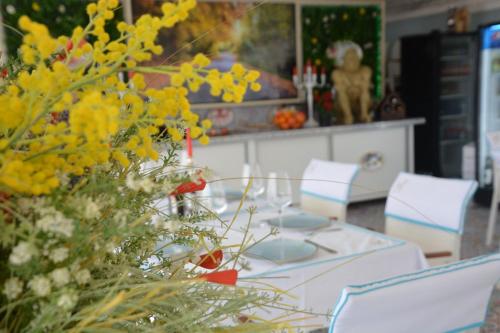a dining room table with chairs and yellow flowers at Boutique Citadel in Eforie Nord