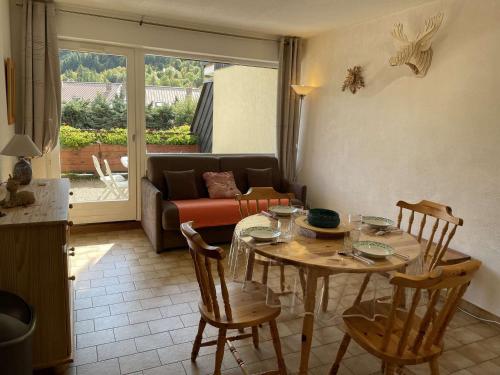 un salon avec une table, des chaises et un canapé dans l'établissement Studio familial à Serre-Chevalier, Chantemerle, avec terrasse et Wi-Fi en option, 4 pers - FR-1-330E-121, à Saint-Chaffrey