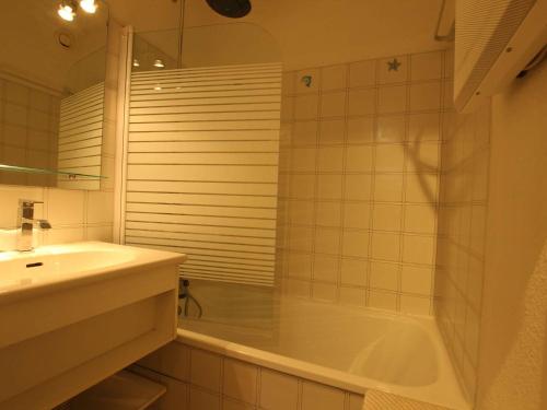 une salle de bain blanche avec une baignoire et un lavabo dans l'établissement Studio familial à Serre-Chevalier, Chantemerle, avec terrasse et Wi-Fi en option, 4 pers - FR-1-330E-121, à Saint-Chaffrey