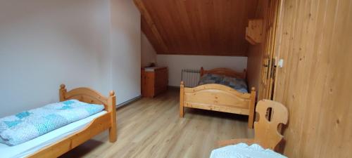 a bedroom with two beds and a wooden floor at Domek na Malinowej in Szczyrk