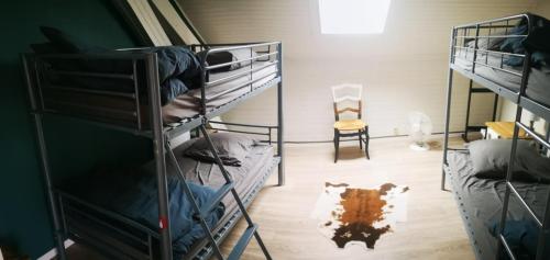 a room with three bunk beds and a chair at Charmant duplex 100m2 in Mouchard