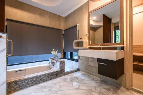 a bathroom with a tub and a sink and a mirror at Mangrovebay Krabi Beachfront Pool Villa in Ban Nai Sa