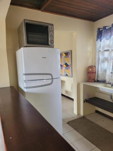 a kitchen with a white refrigerator and a microwave at Apto Duplex com Mezanino in Juquei