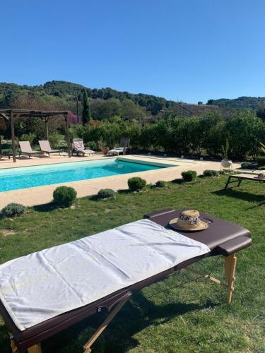 a blanket on a table next to a swimming pool at Mon Chemin Privé in Mirabel-aux-Baronnies