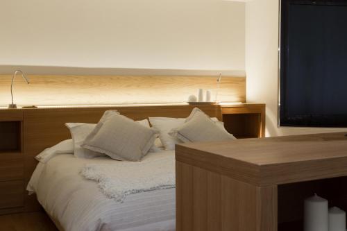 a bed with white pillows and a flat screen tv at Palace Hotel Wellness & Beauty in Bormio