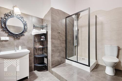 e bagno con doccia, servizi igienici e lavandino. di Loft White by LookAp a Łódź