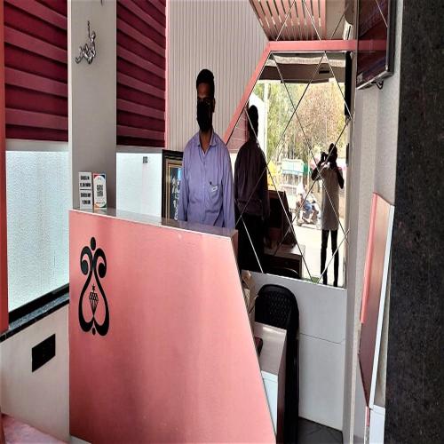 two people standing at the counter of a restaurant at Hotel Rose Gold in Ahmadnagar