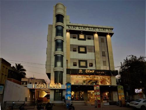 wysoki budynek ze sklepem przed nim w obiekcie Hotel Rose Gold w mieście Ahmadnagar