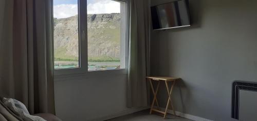 a room with a window with a view of a mountain at Mirador del Bosque Aparts in El Chalten