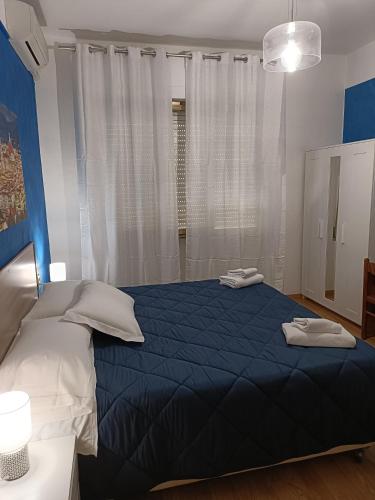 a bedroom with a blue bed with two towels on it at Hotel Alba Serravalle in Serravalle Pistoiese