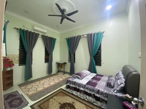 una camera con letto e ventilatore a soffitto di RK ASIANA HOMESTAY, KEMAMAN a Cukai