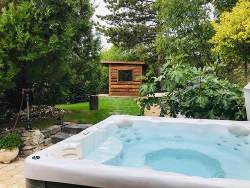 a hot tub in a garden with a bird house at Hilltop Hideout in Szentendre