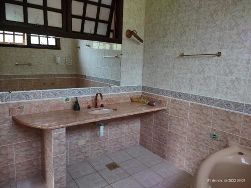 a bathroom with a sink and a tub and a toilet at Solar das Canoas Prumirim in Ubatuba