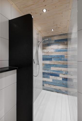 a shower in a bathroom with a wooden wall at Landgasthof Paradies in Frickingen