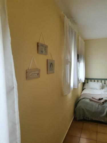 a bedroom with a bed and some pictures on the wall at Apartamento rural La Encina Complejo La Fontanina in Mata de Alcántara
