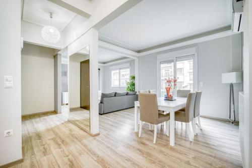 Charming Contemporary 2 bedroom apartment في أثينا: غرفة طعام وغرفة معيشة مع طاولة وكراسي