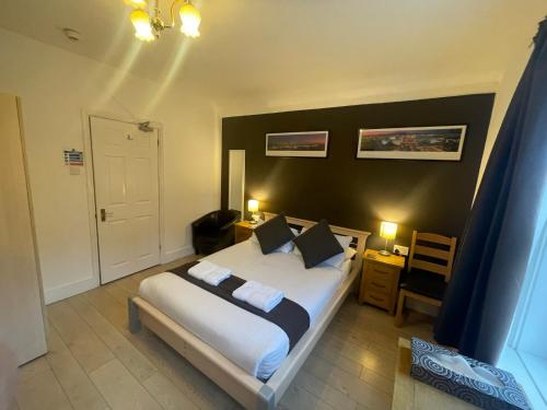 a bedroom with a large bed with white sheets and pillows at Oakhurst Gatwick B&B & bookable Holiday parking deals GATWICK transport in Crawley