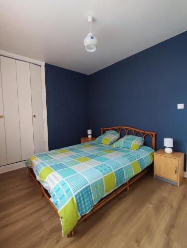 1 dormitorio con 1 cama con pared azul en L'appart, en Limoges