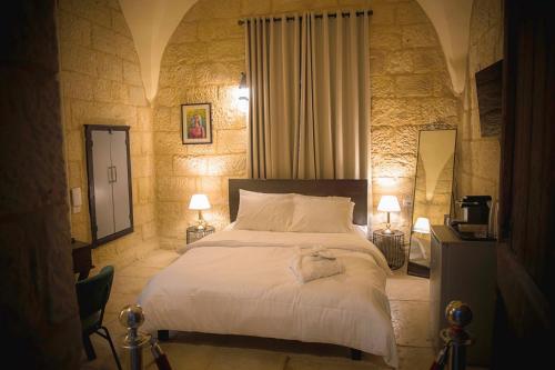 1 dormitorio con 1 cama blanca grande y 2 lámparas en Farah Locanda en Ramallah