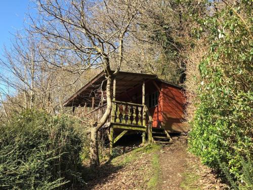 a log cabin with a bench in front of it at Surfers and walkers cosy camping cabin in Ilfracombe