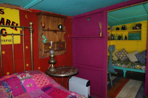 Zimmer mit einem Bett und einer lila Wand in der Unterkunft Surfers and walkers cosy camping cabin in Ilfracombe