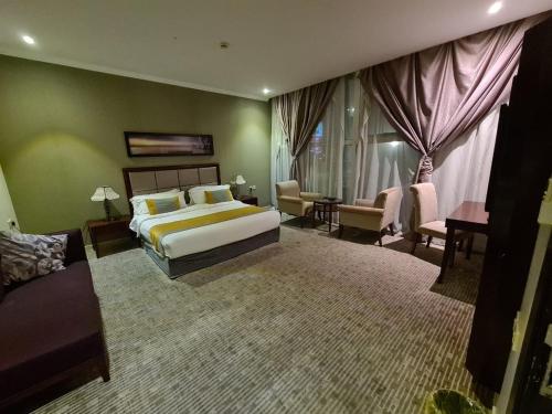 a bedroom with a bed and a living room at تـالـيـن الـهـفـوف in Al Hofuf