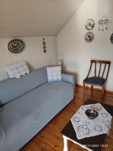 a living room with a blue couch and a chair at Σοφίτα Μαρτά in Kalamos