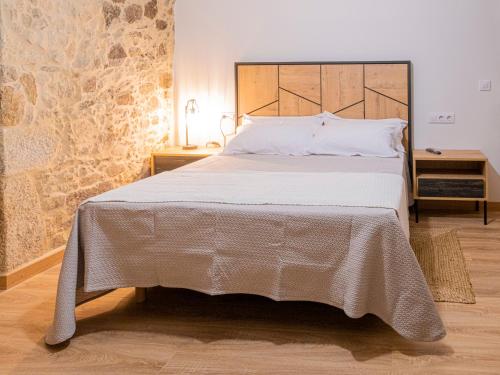 a bedroom with a large bed with a wooden headboard at Casa Rural Laxido in Rianjo