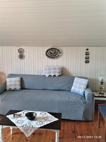a living room with a blue couch and a table at Σοφίτα Μαρτά in Kalamos
