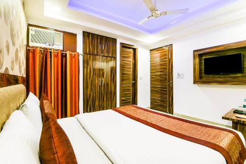 a bedroom with a bed and a television in it at Hotel Pearl - Mahipalpur Delhi Airport in New Delhi